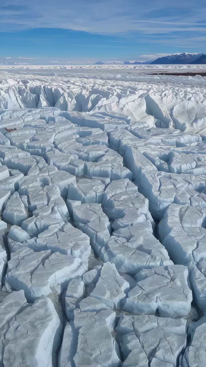 Video verticale: drone che torna indietro su richiesta, rivelando un campo di ghiaccio frantumato e cime innevate per la mappatura