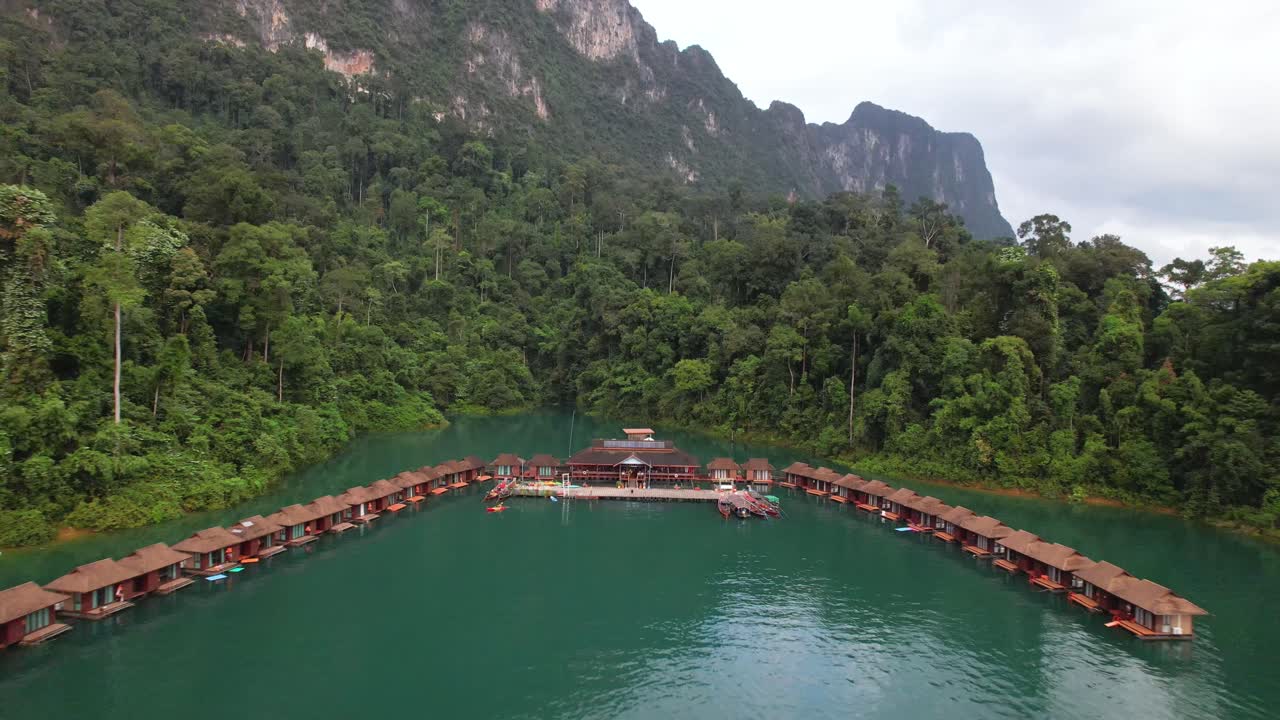 video de dron de 4k volando lejos de los bungalows flotantes en los que puedes alojarte en el parque nacional khao sok, tailandia
