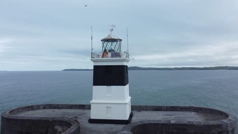 Holyhead-breakwater-lighthouse-longest-concrete-coastal-sea-protection-landmark-aerial-view-close-slow-rotate-right