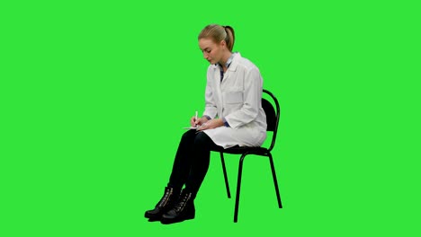 médico femenino escribiendo receta para un paciente en una pantalla verde, clave de croma