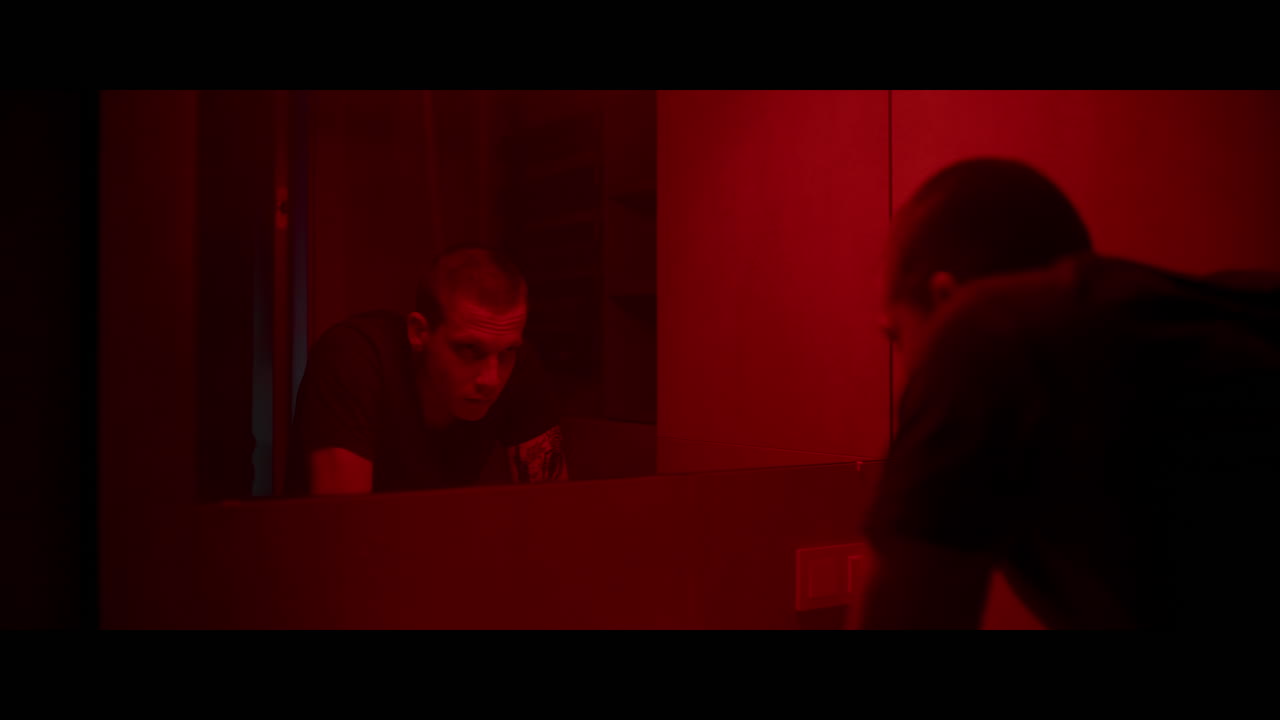 Man in a Red-Lit Bathroom