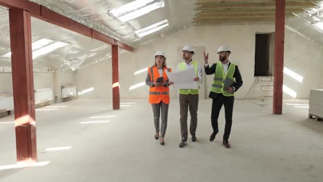 el técnico ingeniero que tiene un plano de la estructura lleva a cabo la inspección del objeto de construcción para la compra de alquiler a los inversores. los especialistas del sitio de construcción pasan por el sitio.