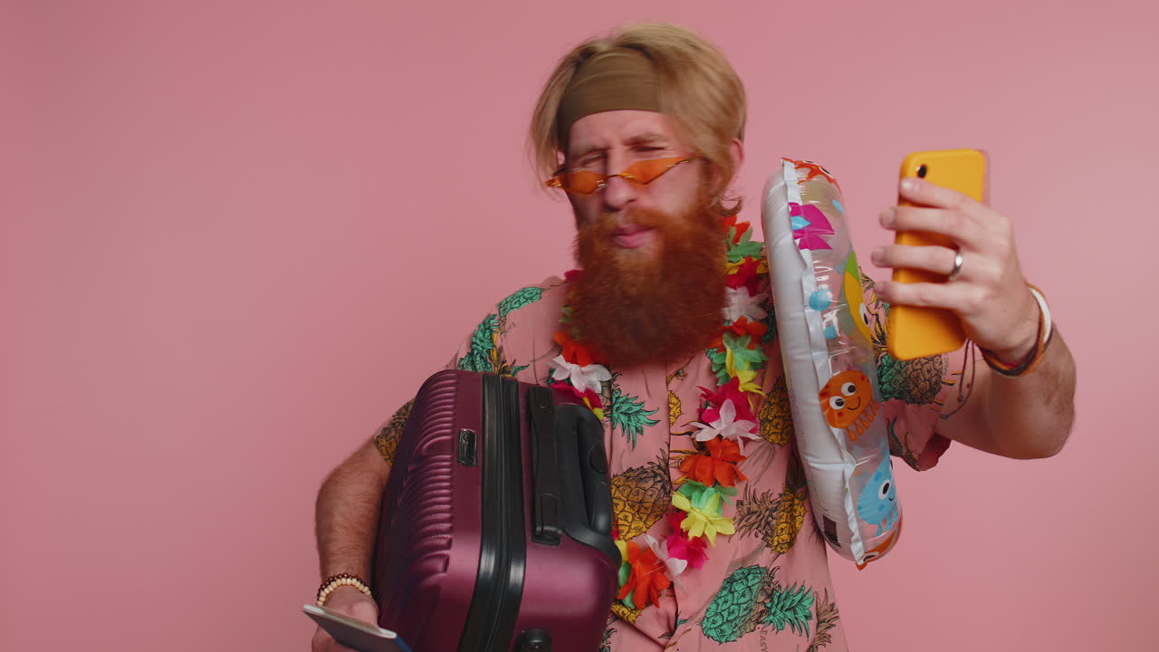 viajero blogger hombre con gafas de sol con equipaje tomando selfies en el teléfono inteligente grabar hacer una videollamada