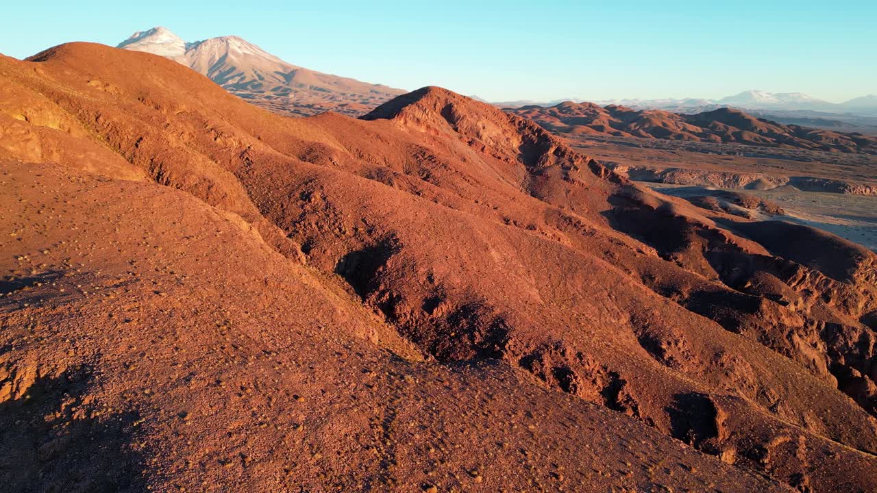 Drone view of the Andes desert landscape at dusk, bathed in surreal Mars-like colors