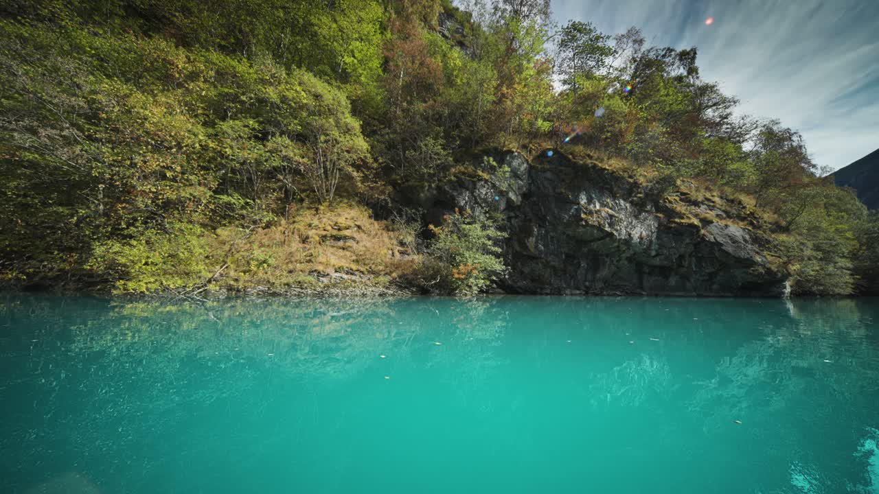 로엔 호수 연안을 고 있는 밀집한 식물은 조용한 푸른 물에 반사됩니다.