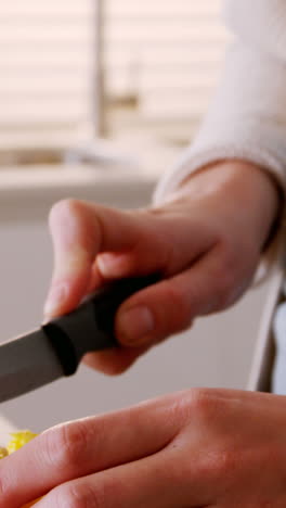Woman cutting red cabbage in kitchen
