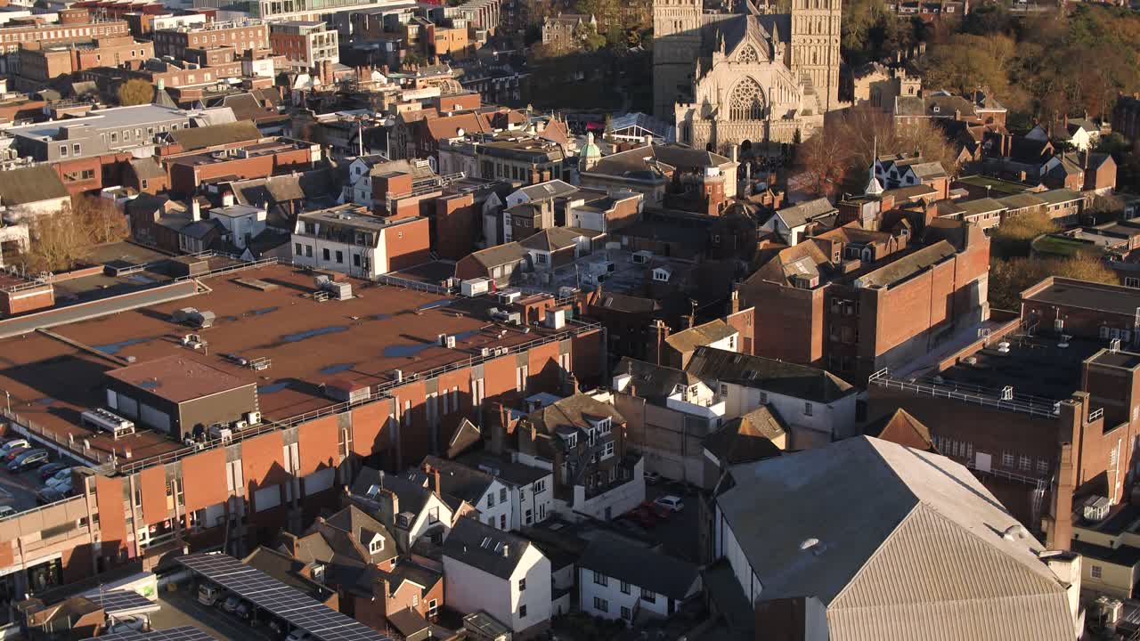 Aerial of Exeter city. Its built up city centre and cathedral dominate the foreground. Wide horizon of the town