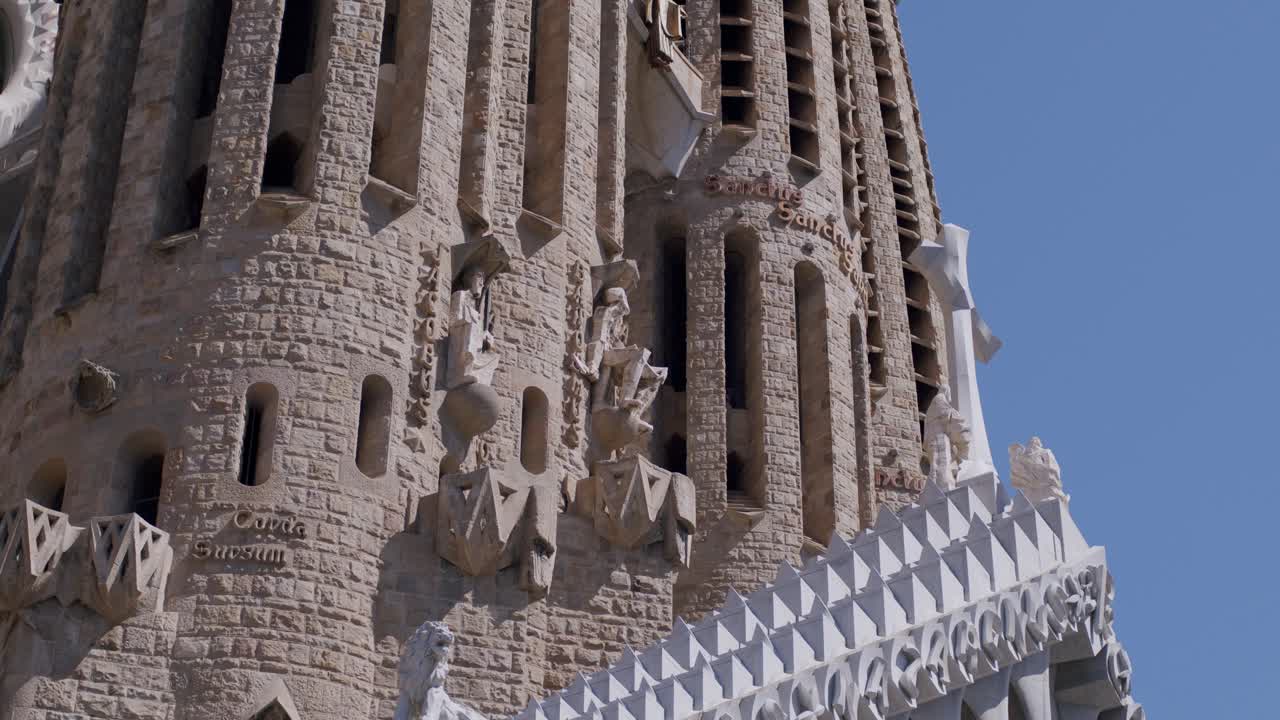Sunlight bathes the intricate facade of Sagrada Familia, showcasing its architectural glory, clear sky