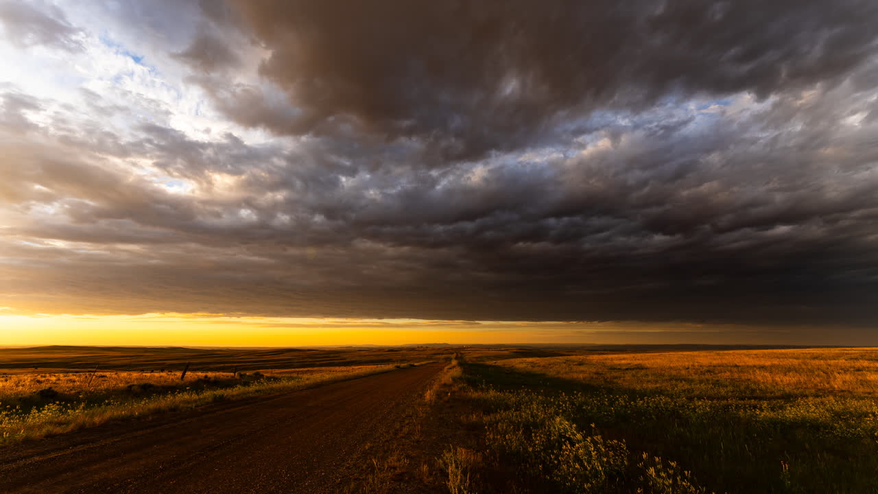 Peaceful sunset scene with clouds drifting over rolling hills