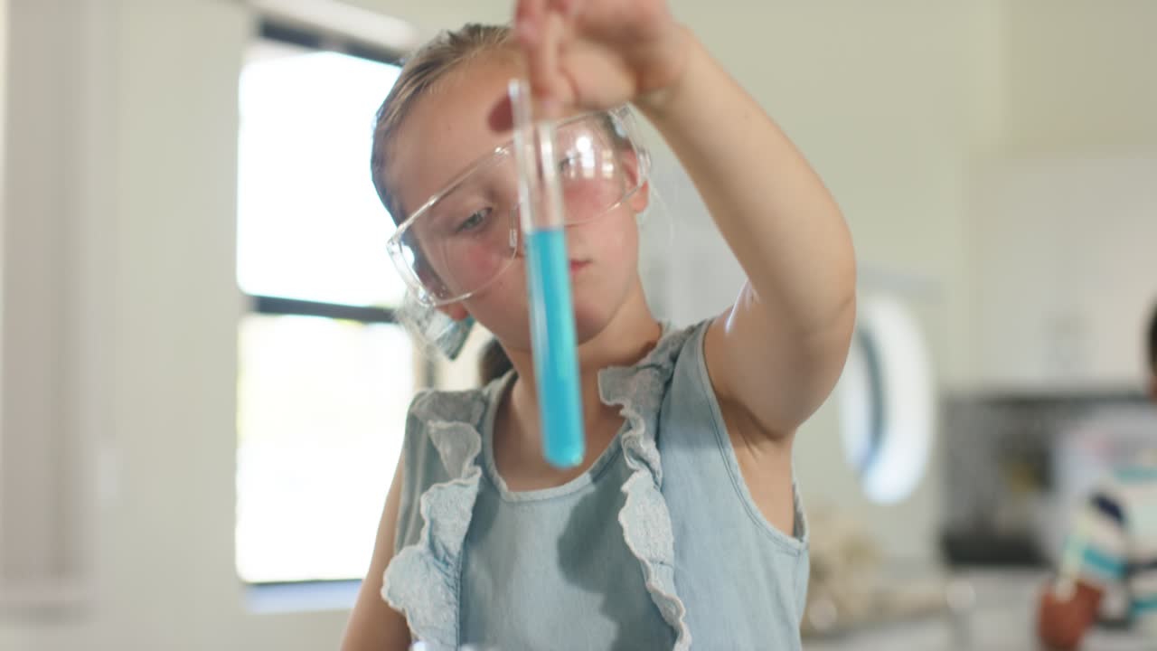 Kids curious, girl in goggles in kitchen raising, inspecting blue tube, placing into rack
