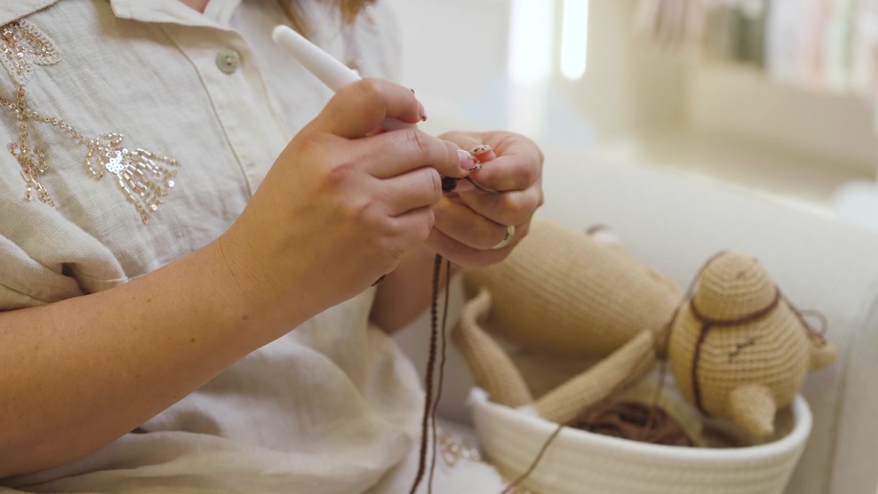 Uno scatto che mostra mani che lavorano con uncinetto e filato, dando forma a un pezzo