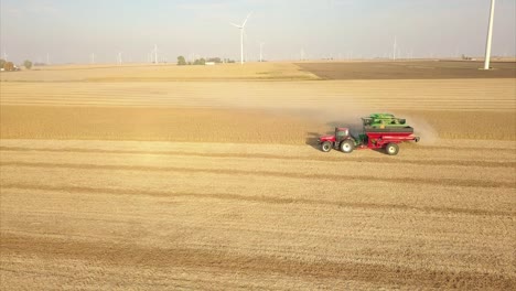 A-Midwest-farmer-harvesting-a-soybean-field-with-a-combine,-tractor,-and-auger-wagon