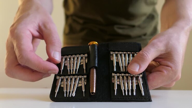 Man preparing precision screwdriver set, close up