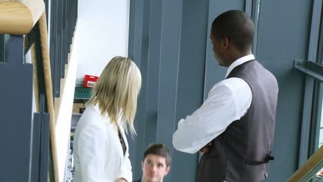 footage of businesswoman and businessmen speaking on stairs