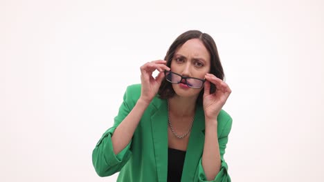 woman in green blazer and glasses reacts with confusion