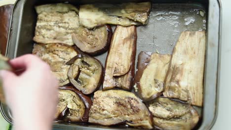 Woman-Laying-Pre-cooked-Eggplant-Slices-in-the-Tray