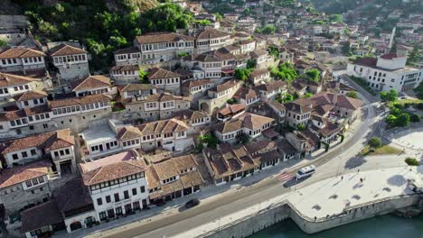 flying over berat old town in albania at sunrise. aerial view old houses and mosques on the embankment of berat