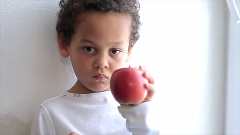 niño con manzana sobre fondo blanco almacen de metraje de video