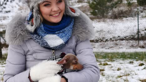 woman playing with her little dog outside winter