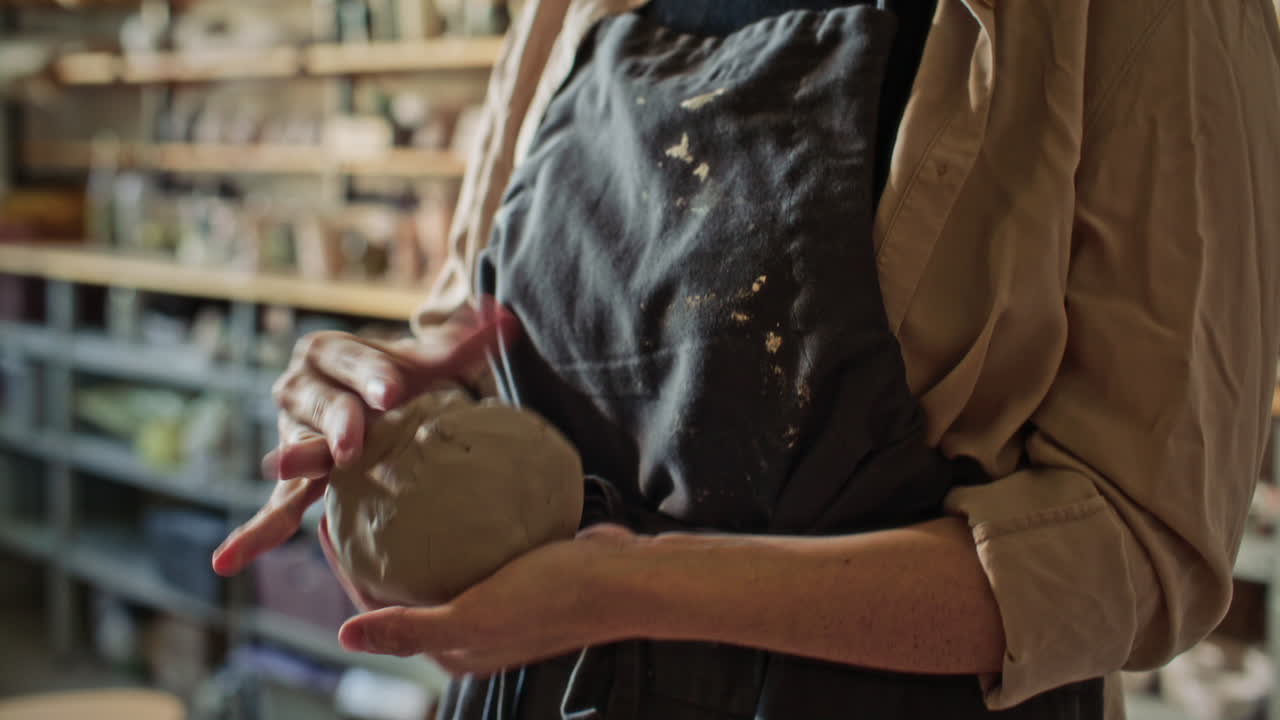 Female Artisan Kneading Clay Ball before Throwing It on Pottery Wheel