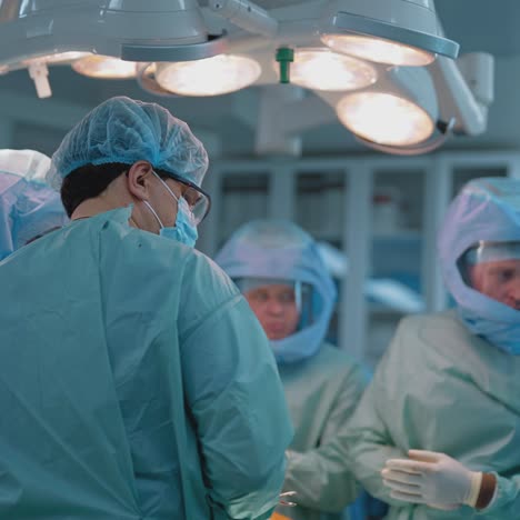 process of trauma surgery operation. group of surgeons wearing protective masks. medical and saving lives concept