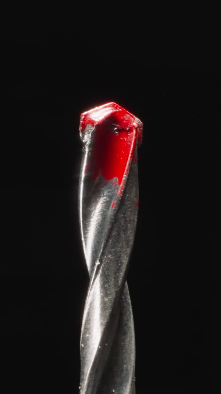Concrete drill bit with carbide tip named pobedite in red paint for making holes at studio light. Professional instrument for workers on black background macro