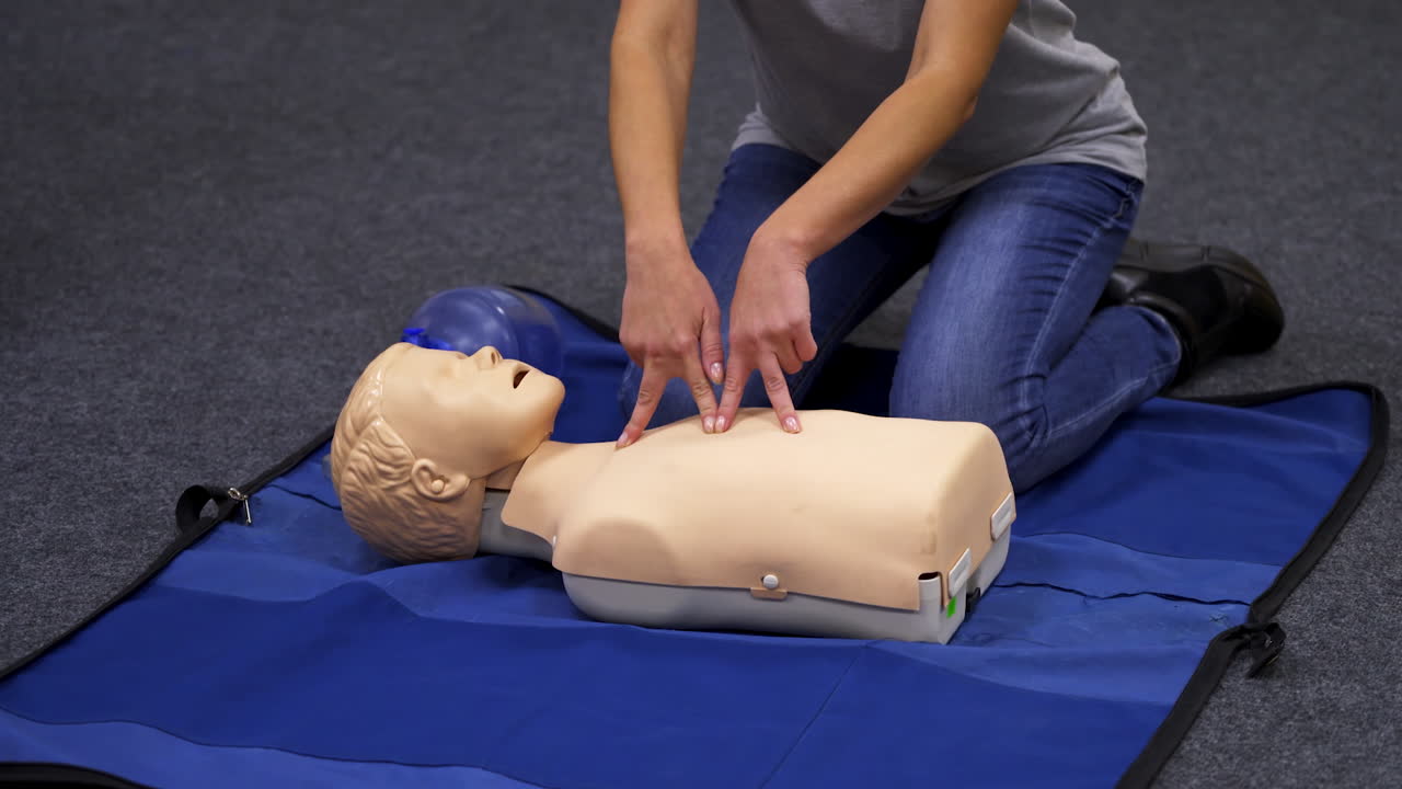 Giving first aid CPR on a dummy. Female trainer demonstrates cardiopulmonary reanimation. Training on a mannequin to save life.