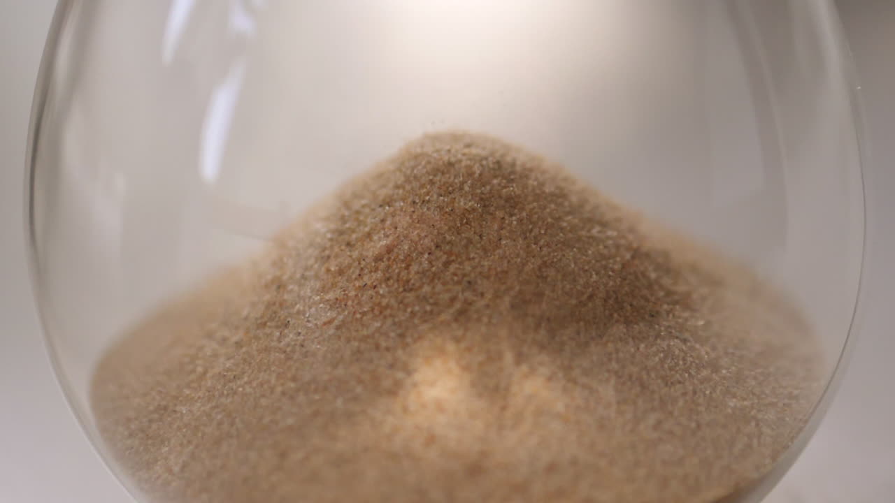 arena de reloj de arena cayendo en cámara lenta de cerca