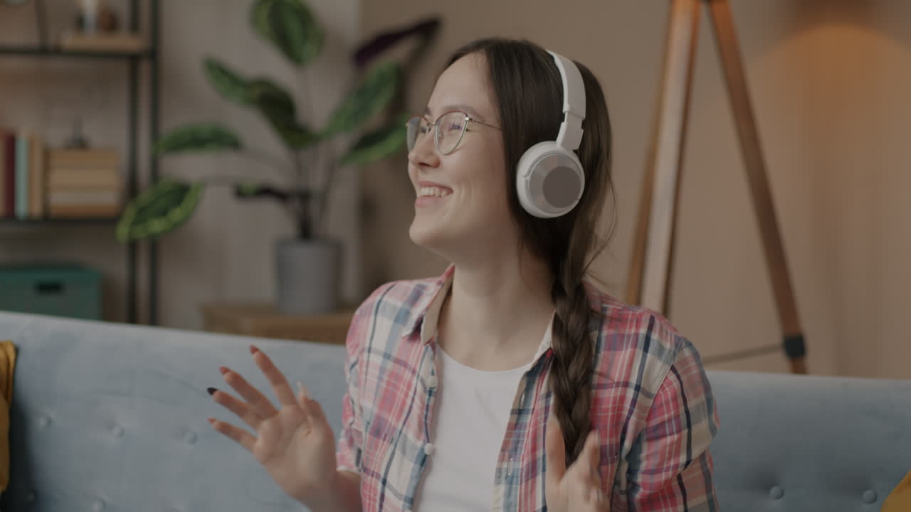 Woman listening to music and dancing on a sofa