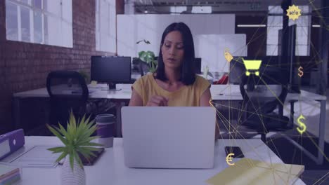 animación de un globo de iconos digitales girando sobre una mujer biracial pensativa que usa una computadora portátil en la oficina