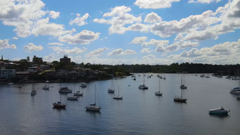 Drone-shot-oskimming-ver-the-top-anchored-boat-masts-on-a-calm-day-in-a-harbour