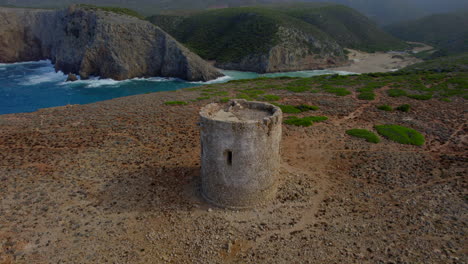 fantastic aerial view in a circle over the torre di cala domestica and its beautiful nearby beach of the same name