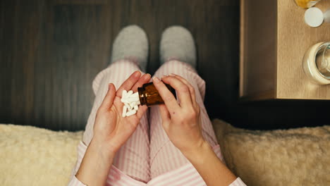 woman taking medicine in bed