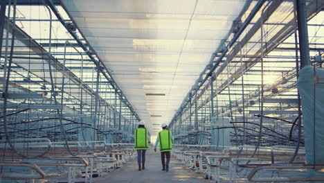 engineers walking empty factory discussing production process plan in uniform