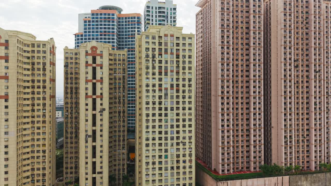 Drone sobe revelando densas torres residenciais, Eastwood City, Manila
