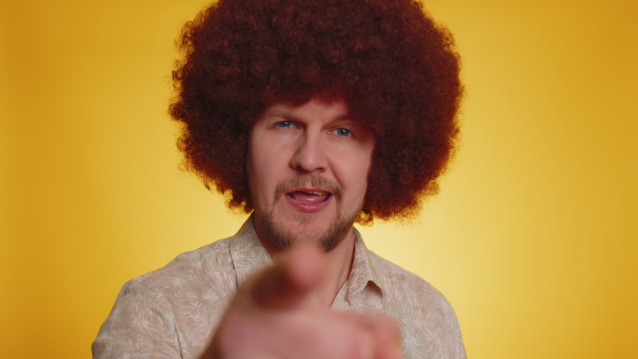 hombre apuntando a la cámara y mirando con expresión alegre juguetona haciendo la elección del afortunado ganador