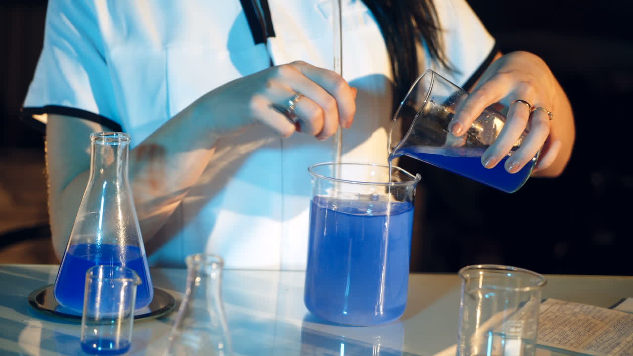 Young woman working in laboratory on experiments. Testing chemicals in laboratory