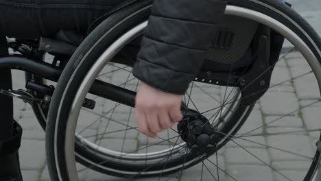 woman in a wheelchair wheeling herself outside.