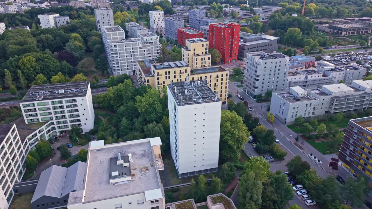 Pan left drone view of La Courrouze district with red buildings and morning light - Rennes