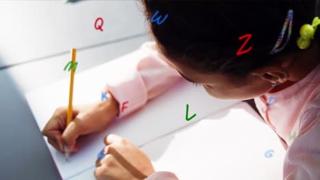 animación de letras coloridas flotantes sobre una niña sentada en el aula escribiendo