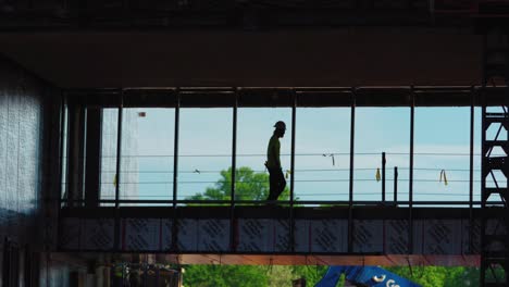 Silueta,-Toma-En-Cámara-Lenta-De-Un-Trabajador-De-La-Construcción-Cruzando-Una-Pasarela-De-Puente