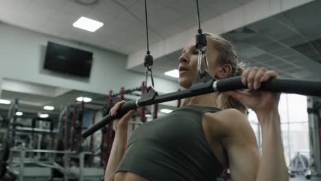 mujer joven haciendo ejercicio con pesas en un gimnasio.
