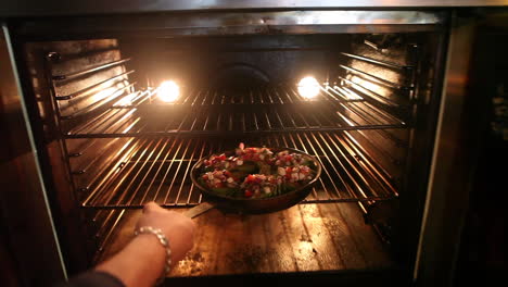 a fresh pizza is placed in an oven