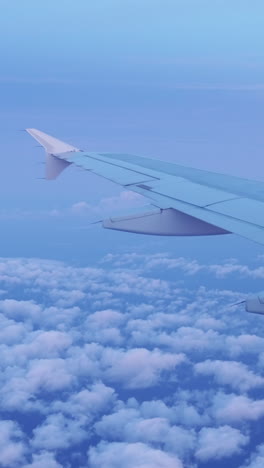 vista desde una ventana de avión del cielo al amanecer con el ala del avión en el tiro en vertical