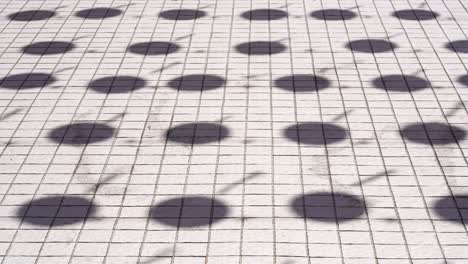 shadows on floor of the lanterns swaying in the breeze under the bright sunlight