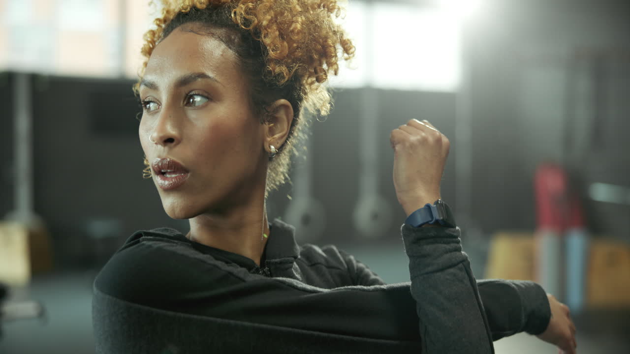 mujer estirándose en un gimnasio