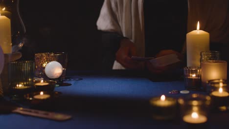 primer plano de una mujer dando una lectura de tarot en la mesa a la luz de las velas 10