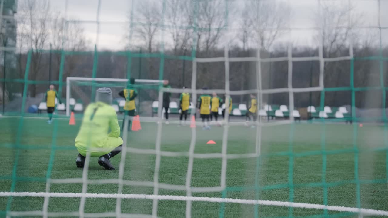 어린이 축구팀은 코치의 지도하에 경기장에서 훈련합니다. 스포츠 유니폼을 입은 아이들은 공 연습을 하고, 기법을 개선하고, 그린 필드에서 팀워크를 개발합니다.