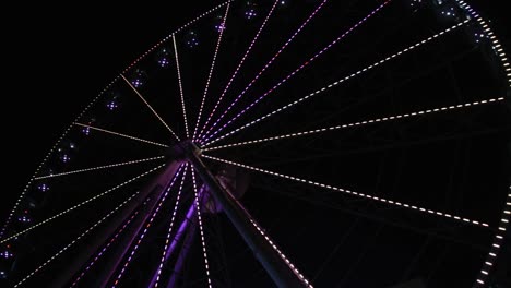 amusement park at night - big ferris wheel with festive neon illumination against night sky