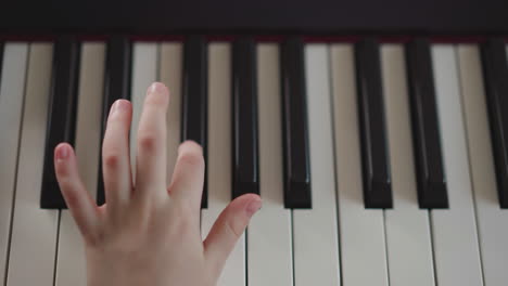 child hand adjusts volume on slider on electronic synthesizer